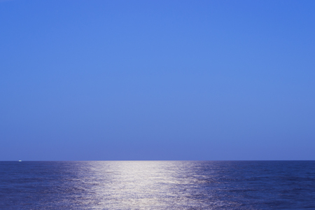 Moonlight reflects from the sea surface. Authentic summer landscape in blue tones. Torrevieja, Alicante, Spainの写真素材