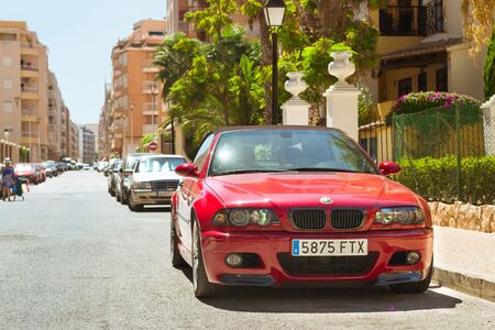 TORREVIEJA, SPAIN - SEPTEMBER 13, 2014: Red modern coupe-car BMW M3 series on sunny street, Calle Jacinto Benavente, Torrevieja, Valencia, Spainのeditorial素材