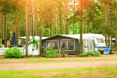 Summer outdoor recreation, Scandinavian vacation. Camping vans and tents parked in a wooded campsite among pine trees. Finnish Gulf. Area for camp in woods. Hamina, Finland, Suomiのeditorial素材