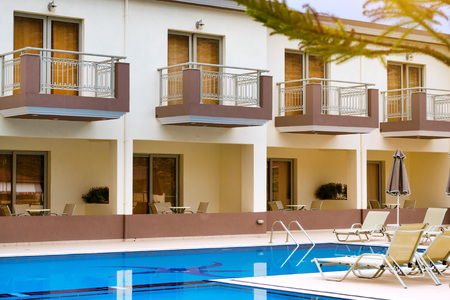 BALI, GREECE - APRIL 29, 2016: Empty sunbeds and umbrellas are at the pool empty without tourists early in morning. Relax and sunbathe by pool with clear blue water in Resort hotel Bali, Crete, Greeceのeditorial素材