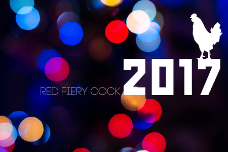2017 with Cock on festive Christmas background with bokeh from New-year tree lights glowing. Rooster is symbol of New 2017 year of red fiery cock. Blurred colorful circles on holiday backgroundの写真素材