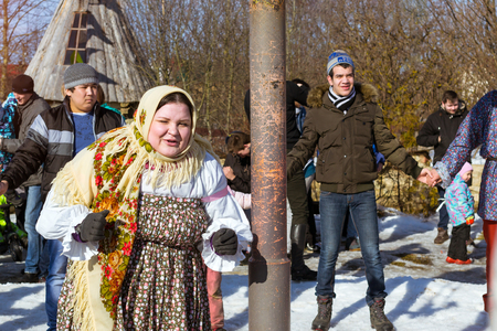 Saint-Petersburg, Russia - March 13, 2016: Shrovetide festivities, pancake week. Adults and children celebrate end of winter and beginning of spring, Mardi Gras celebration outdoors on snowy meadow. Funny Nicholas Fortressのeditorial素材