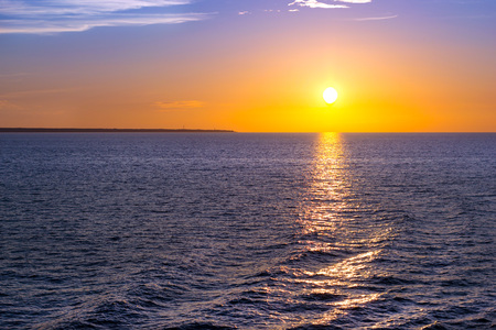 Sunset over sea horizon. Bright sun is reflected from water surface, evening sky with sparse Cirrus clouds. Sea Nordic walk on passenger ferry from Helsinki to Tallinn. Tallinn Bay, Finland-Estoniaの写真素材