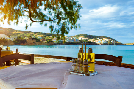 Cooking set olive oil, salt, pepper, condiments and toothpicks are on table at beach cafe on the seafront. Livadi beach in sea bay of resort village Bali in may. Bali, Crete, Greeceの写真素材