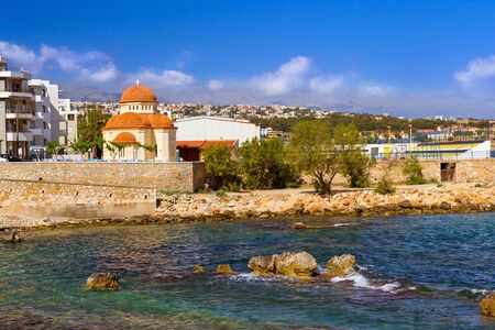Eastern Orthodox Church of Holy Chapel Of Saint Nicholas. Place of worship on coast of Kolpos Almirou in Greek resort Rethymno. Promenade Leof. Emmanouil Kefalogianni is washed by Cretan sea. Greeceの写真素材