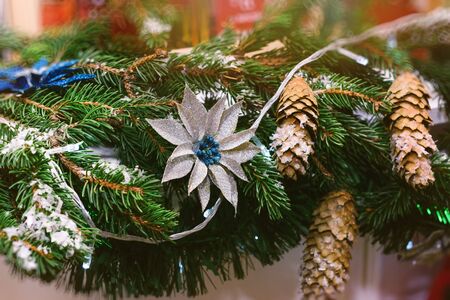 Christmas spruce branches with cones and festive decorations. Celebration of New year and Christmas at home. Holiday decorations and backgrounds from natural and artificial materialsの写真素材
