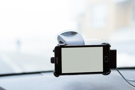 Car smartphone holder with phone attached to the windscreen of automobile. Accessories for vehicles,...