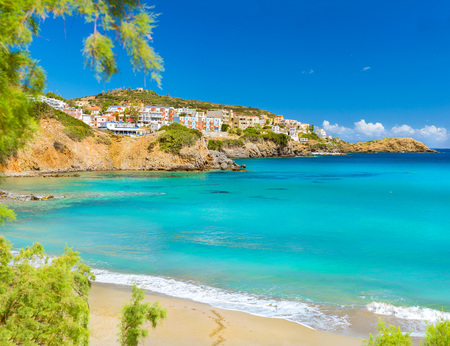Sunny sandy Livadi beach in sea Bay of resort village Bali. Sea waves wash the sandy beach. View of rocky coast with white houses. Bali, Rethymno, Crete, Greeceの写真素材
