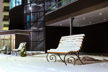 Modern building made of glass and concrete amidst a snowy winter landscape at night. Severe Northern winter and snowy weather. Snow-covered wooden benches. Narva-Joesuuの写真素材