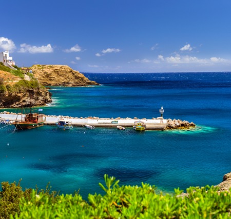 Harbour with marine vessels, boats and lighthouse. View from cliff on Bay with architecture Bali. Vacation destination resort, with beaches and clear turquoise ocean waters, Rethymno, Crete, Greeceの写真素材