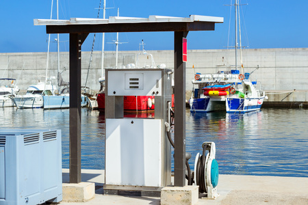 White fuel dispenser at boat filling station on waterfront, port Blanes. Oil industry for water transport. Fishing boats and yachts moored in marina. Seaport Blanes, Spain, Costa Brava, Cataloniaの写真素材