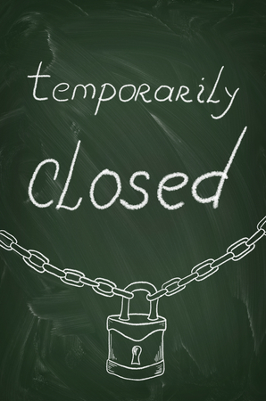 Temporarily closed caption written on a blackboard with chalkの写真素材