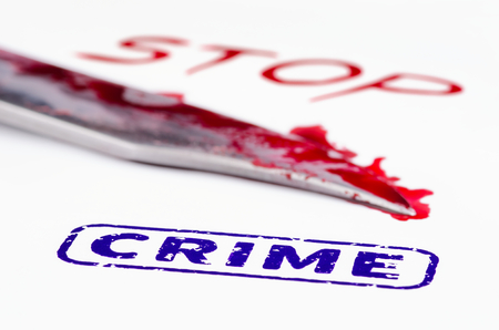 Macro shot of stamp crime on a white paper. Knife and stop written in blood.の写真素材