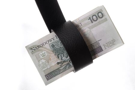 Belt tightening a wad of banknotes, symbol of the crisis of the financial, proverbial belt-tightening.の写真素材