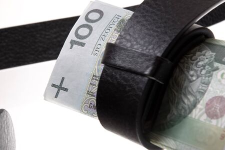 Belt tightening a wad of banknotes, symbol of the crisis of the financial, proverbial...