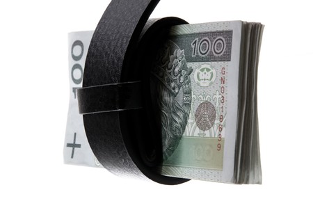 Belt tightening a wad of banknotes, symbol of the crisis of the financial, proverbial belt-tightening.の写真素材