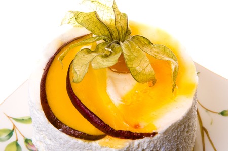 Decoration on a piece of cake from fruits and leaflets. Cake of the whipped cream and fruits isolated on white background.の写真素材