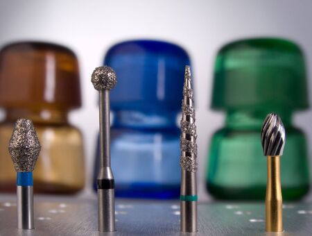 Dental burs on glass-stoppered flasks background