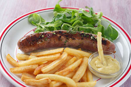 grilled sausage and french fries with saladの写真素材