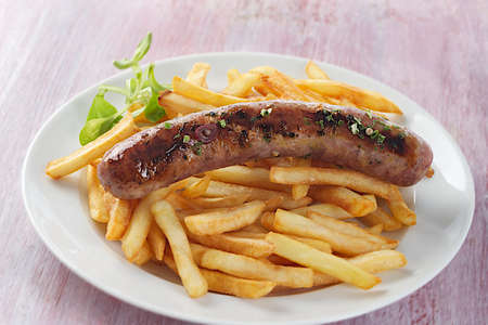 grilled sausage and french fries with saladの写真素材