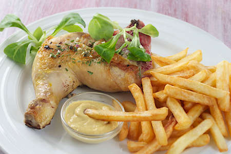 grilled chicken leg and french fries with saladの写真素材