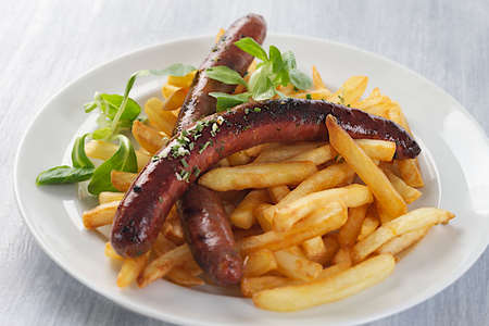 grilled sausage and french fries with saladの写真素材