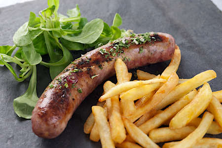 grilled sausage and french fries with saladの写真素材