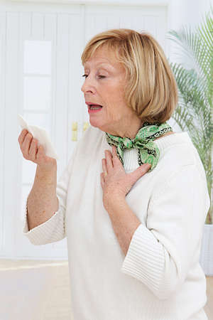 Elderly woman has flu and sneezing hardlyの写真素材