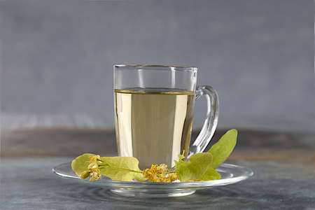 Cup of herbal tea with linden flowers on grey backgroundの写真素材