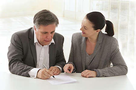 Image of business woman pointing document to business man  for signature  at the office