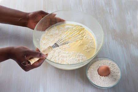 Woman whisking batter in kitchen