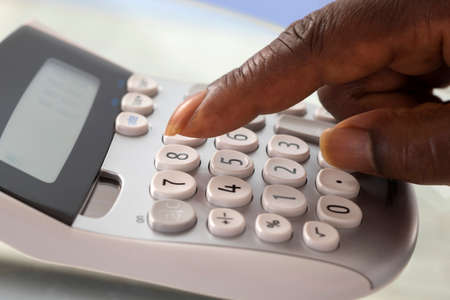 Fingers pressing on calculator keypadの写真素材