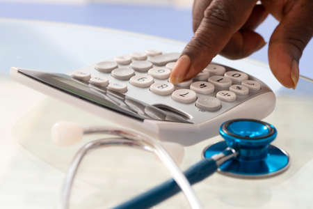 Fingers pressing on calculator keypadの写真素材