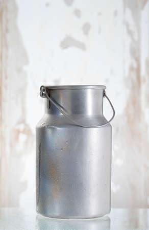 old jug of milk isolated on wooden backgrounfの写真素材