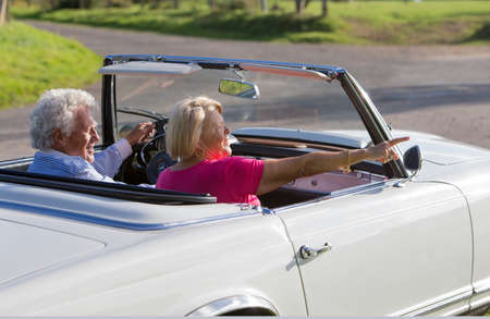 Senior couple in convertible car enjoying day trip
