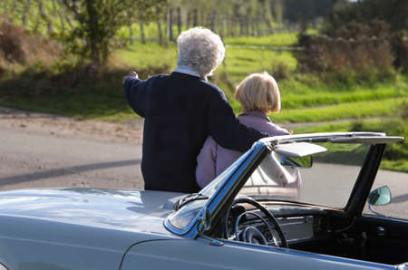 Back view of Mature couple by car in countrysideの写真素材