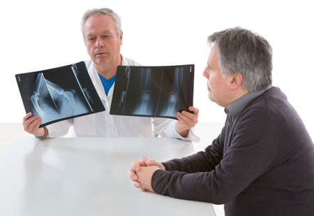 Doctor showing diagnosis of x-ray image to patient sitting at desk office.