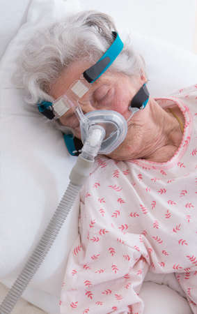 elderly  woman is sleeping with a CPAP machine