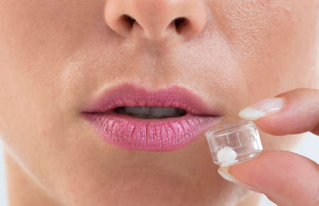 Young woman tacking homeopathy pills