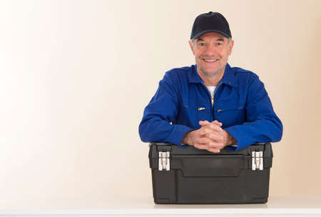 Mature happy craftsman with tool boxの写真素材