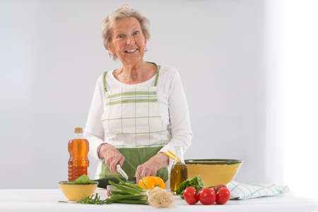 Happy senior woman  cooking at kitchenの写真素材