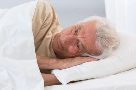 Man lying in bed sleepingの写真素材