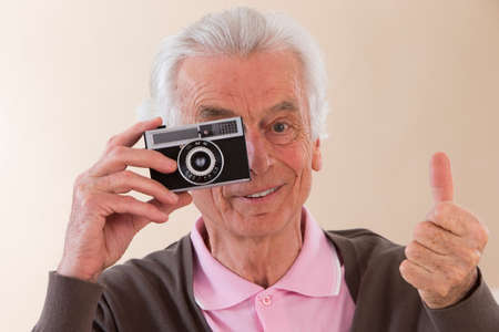 senior cool man with a vintage cameraの写真素材