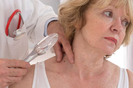 dermatologist focus on senior woman beauty spot