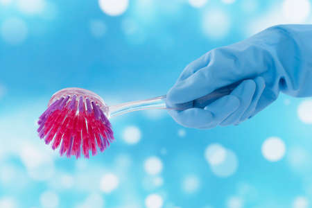 Gloved  hand holding a cleaning brushの写真素材