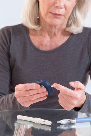 woman with test strip and blood glucose meterの写真素材