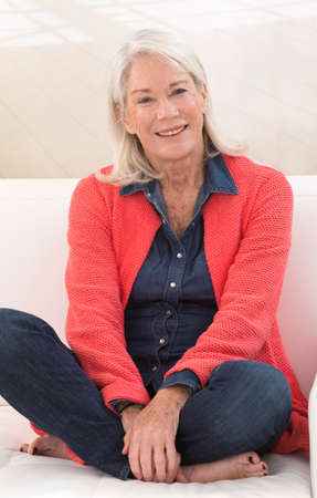 portait of a senior woman relaxing on her sofa at homeの写真素材