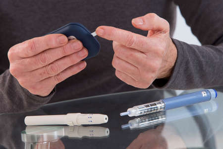 hands of senior with utensils of blood sugar test