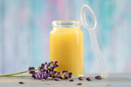 raw organic royal jelly in a small bottle with flowersの写真素材