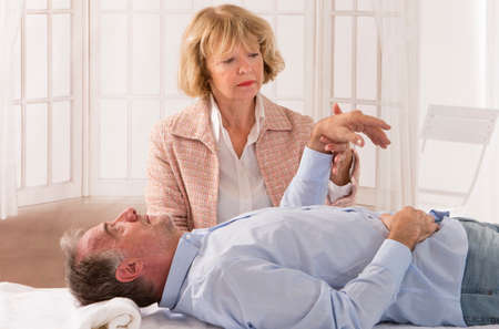 Senior man patient undergoing hypnotherapyの写真素材